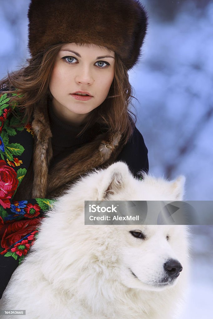 Bella donna in Cappello di pelliccia di inverno foresta con cane - Foto stock royalty-free di Abiti pesanti