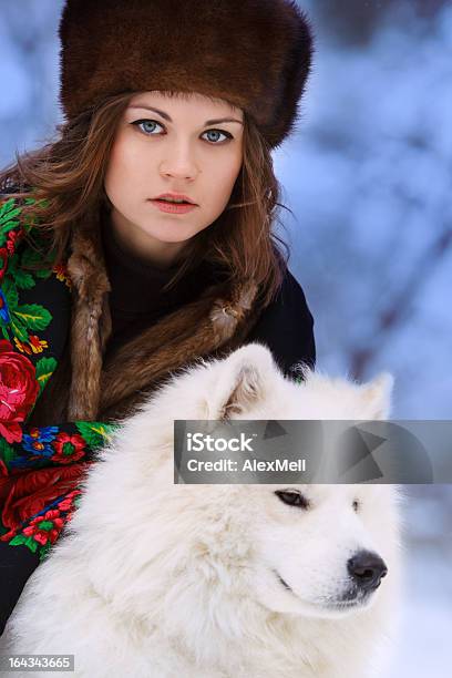 Bella Donna In Cappello Di Pelliccia Di Inverno Foresta Con Cane - Fotografie stock e altre immagini di Abiti pesanti