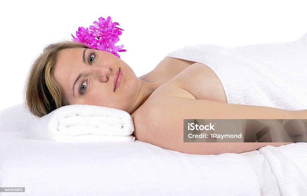 Day spa aroma therapy and massage Spa therapy pretty young blond woman looking at camera, partial nude enjoying aroma therapy covered with towel laying on massage table. In studio on white background. 20-29 Years Stock Photo