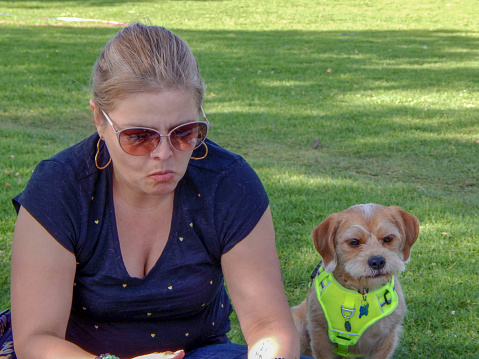 woman and dog with the same face in a park