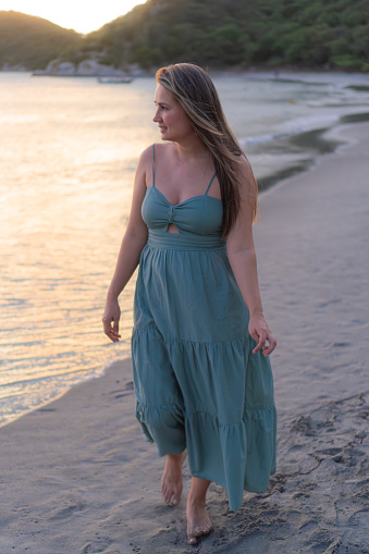 woman savoring a serene sunset beach walk