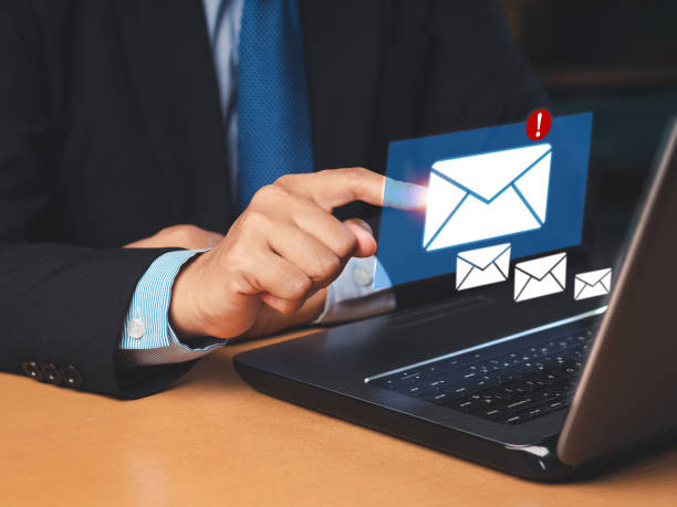 istock Businessman receives a new message with email icons on a virtual screen 1643452489