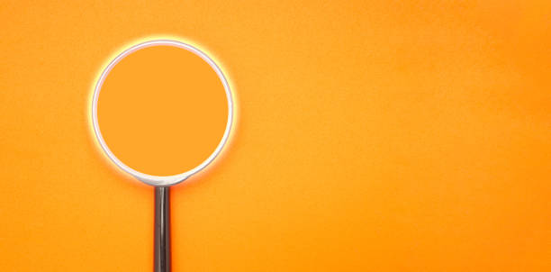 istock A magnifying glass on orange background. Search concept 1643458340