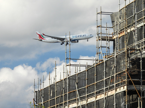 A SriLankan Airways Airbus A330-343 plane, registration 4R-ALO, passing a new building construction in Marrickville as she comes into land from the north at Sydney Kingsford-Smith Airport from Colombo as flight UL606.  This image was taken from Marrickville windy, cold and cloudy afternoon on 26 August 2023.