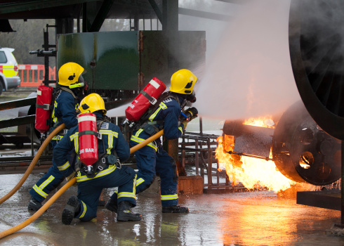 Team of firemen extinguishing an industrial fire.