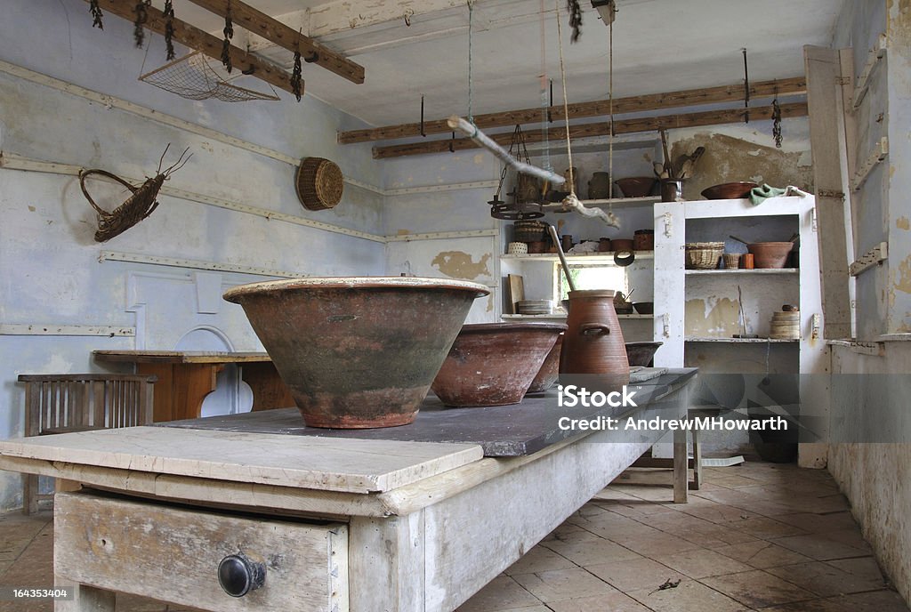 Bowls in the dairy A selection of bowls and containers on a marble topped table in an old fashioned dairy.  The scene is empty and illustrates the environment, tools and equipment involved in producing butter and cheese by hand, in a traditional and now forgotten way.  Used for Tudor reenactment in Suffolk, England. Abandoned Stock Photo
