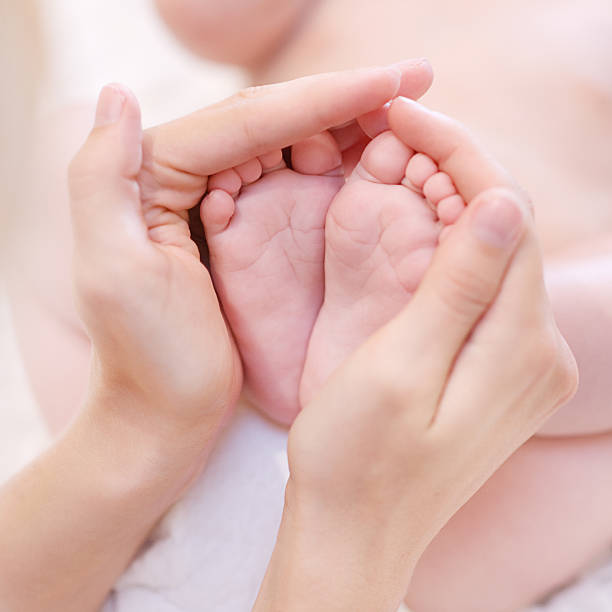 istock Baby feet cupped into mothers hands. 164354825