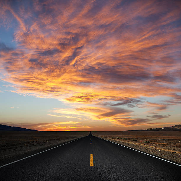 istock A lonely road leading into a beautiful sunset 164355317