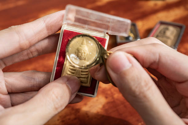 istock Using a loupe to see the detail on an old Thai Buddha amulet 1643574527