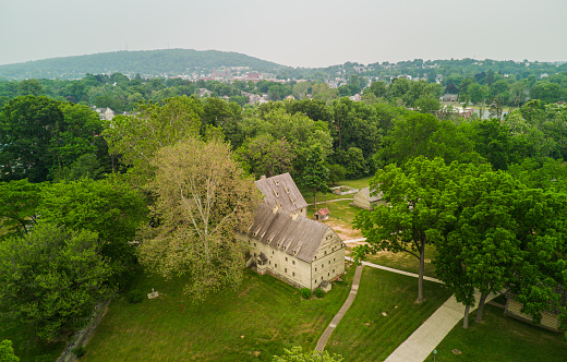 Historic Ephrata Cloister in smog from Canadian fires. Trees, hills and a serene blue sky make panorama in PA.