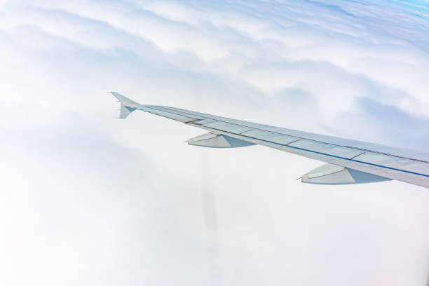 istock View from the airplane window at a beautiful cloudy sky and the airplane wing 1643598330