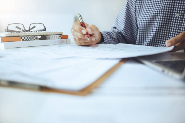 istock businessman working and reviewing  documents on desk 1643599323