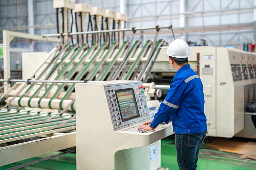 Expert engineering working in a manufacturing line in a Printing Plant factory.