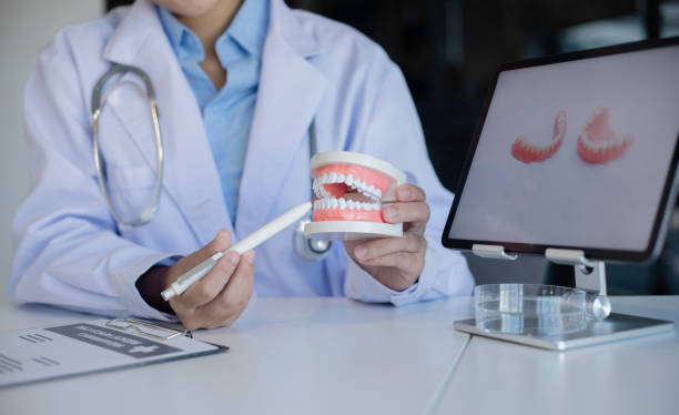 istock Dentist With Tooth Model At Dental Clinic. 1643689276
