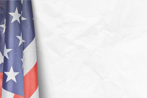 Crisp, bright and vibrant waving, pleated or twirling American national flag over blank white crumpled paper background for copy space. Apt for use as posters, banners, backdrops, greeting cards for US Independence Day, 4th of July, labour Day Memorial Day. There is No people and no text.