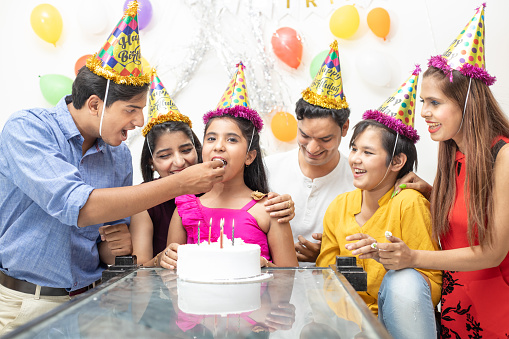 Happy Indian asian family or friends celebrate birthday. Eat cake, holidays and people concept.