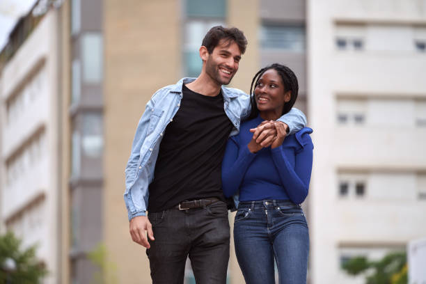 istock Multi-Ethnic couple smiling while walking on the street together. 1643701498