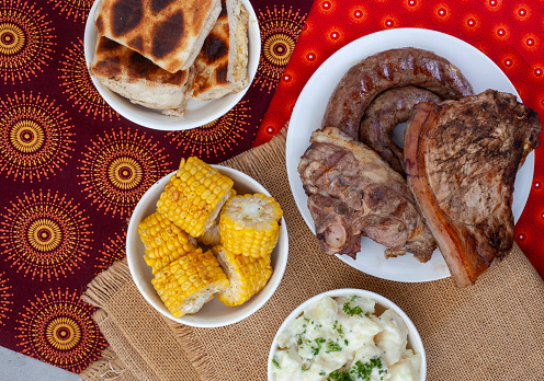 South African Braai Day or Heritage Day. Celebrating traditional braai food.\nMeat and sides with traditional Shwe - Shwe cloth.