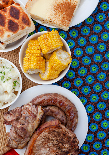 South African Braai Day or Heritage Day. Celebrating traditional braai food.\nMeat and sides with traditional Shwe - Shwe cloth.