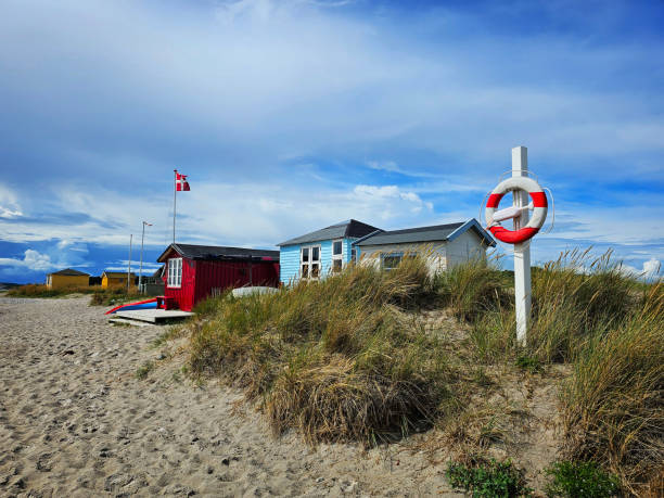 Tiny wooden summer house or beach shelter few feet from the waterfront.  Vacation idyll at the edge of the beach