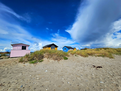 Tiny wooden summer house or beach shelter few feet from the waterfront.  Vacation idyll at the edge of the beach