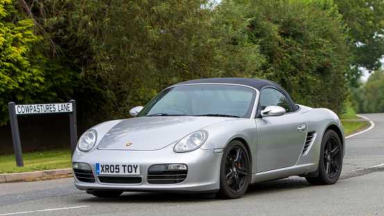 Whittlebury,Northants,UK -Aug 26th 2023: 2005 silver Porsche Boxster car travelling on an English country road