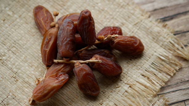 istock dried dates on wooden table with mat. 1643739346