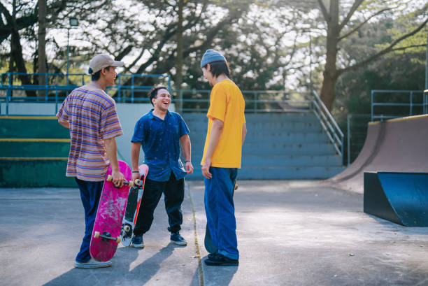 istock Multiracial young men standing in skateboard park talking resting after skateboarding 1643747902