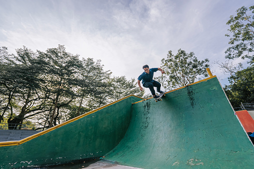 Romanian male skateboarder in action mid air skateboard park