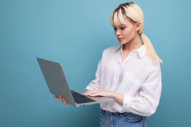 Free Stock Photo of A young blonde woman working on her laptop ...