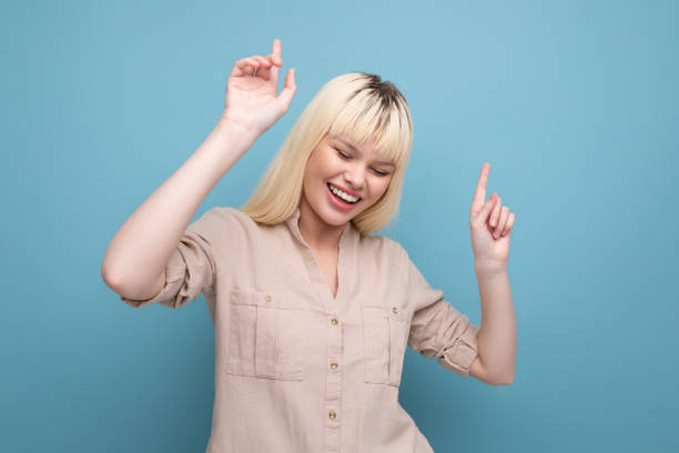 istock dancing blond woman in a shirt 1643769073