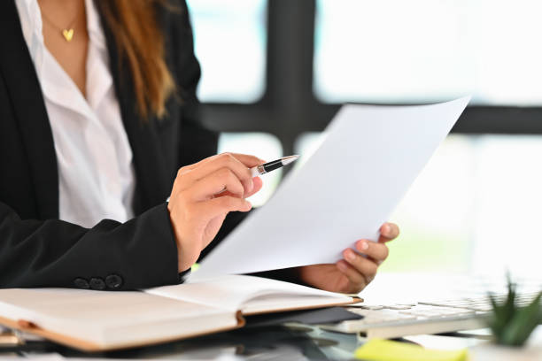 istock Cropped shot of female manager reading paper document, analyzing marketing data, statistics, financial results at office desk 1643799326