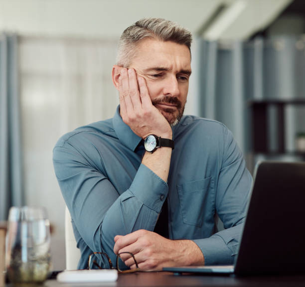 istock Confused, bored and business man at laptop in office with stress, fatigue and problem. Computer, tired and mature manager with doubt, financial crisis and reading debt email, tax audit and burnout 1643806643