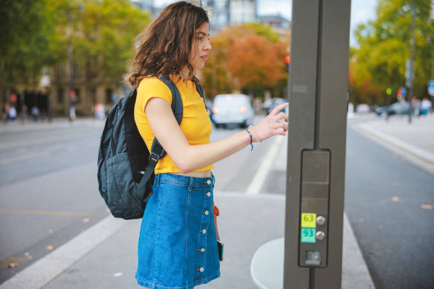 istock Beautiful university student with backpack reading map routes on bus stop banner 1643810853
