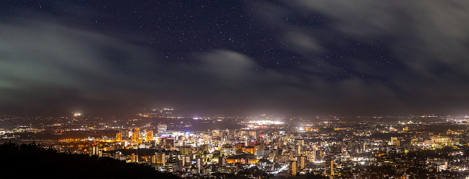 A high-angle wide panorama view over Morioka City at night with stars.
