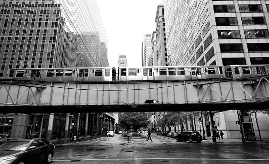 Chicago 'L' elevated train crossing LaSalle street between urban buildings, Illinois, USA.