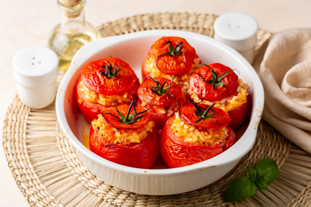 śródziemnomorska kolacja. garnek z pieczonymi w piecu nadziewanymi pomidorami z ryżem, serem i bazylią. - stuffed tomato zdjęcia i obrazy z banku zdjęć