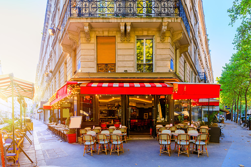 Paris, France - August 6, 2022: Parisian street with tables of a brasserie (restaurant).