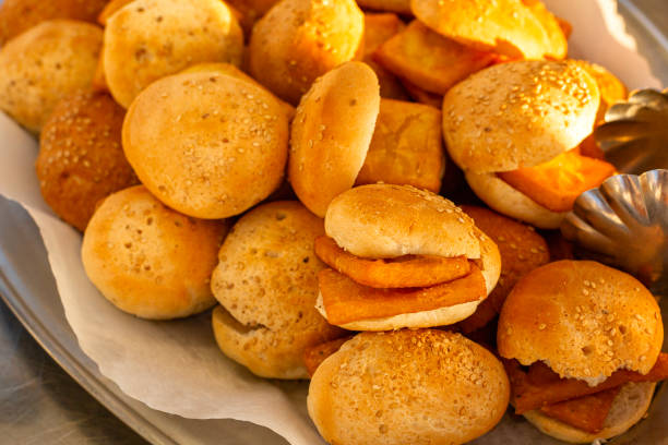 Features a variety of bread products on the table.