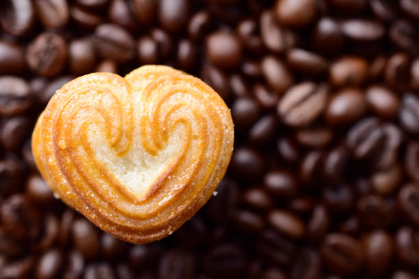 istock Top view of heart shape cookie on coffee bean background 1643828101