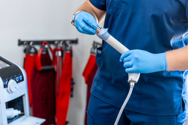istock Shock wave therapy device with male doctor hands in rubber gloves. 1643829229