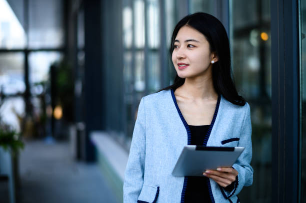istock Asian young woman using digital tablet in coffee shop 1643833984
