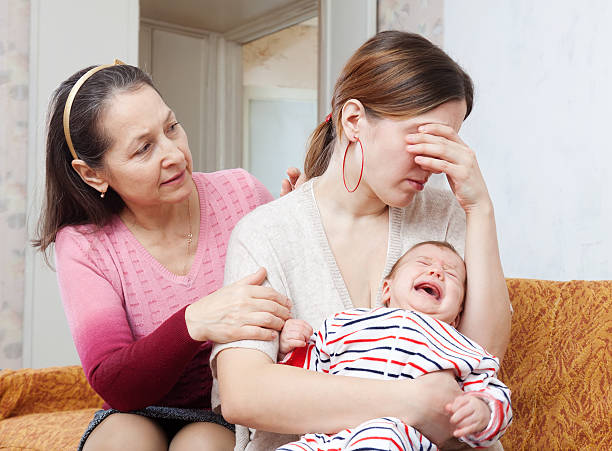 Mature woman gives solace to crying adult daughter Mature woman gives solace to crying adult daughter with baby at home woman comforting depressed friend stock pictures, royalty-free photos & images