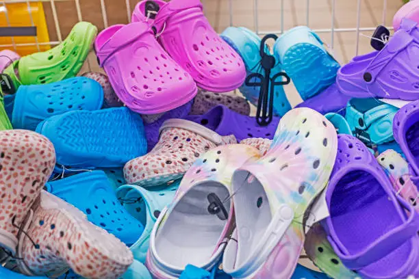 Photo of background of colorful crocs on the supermarket counter, sale