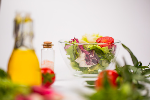 Fresh spring vegetables, salad, spices on a white background