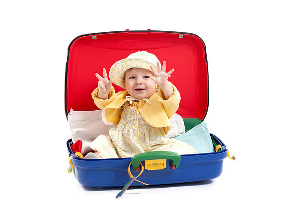 istock baby girl seated in a suitcase on white 164384531