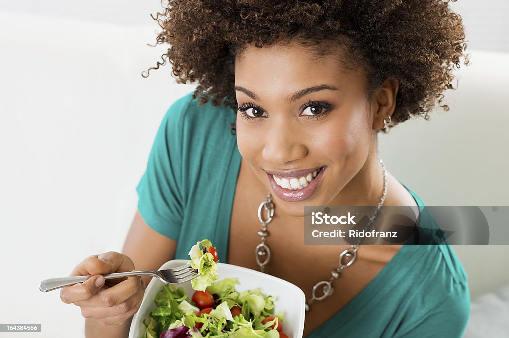 Afro-americana donna mangiare Insalata - Foto stock royalty-free di 16-17 anni