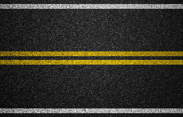 Black road graphic with yellow central marking and white