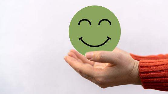 Hand holding paper cut circle symbol face smile, happy, relax,  satisfaction survey, customer services, positive, good, wellness, health child, hospital, world mental health day concept