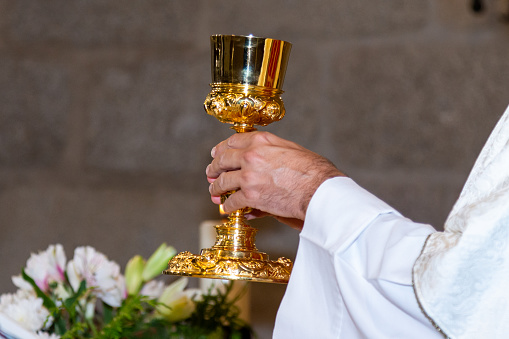 Eucharist ceremony during mass.  Catholic ritual.  Priest in a white cassock celebrating mass.